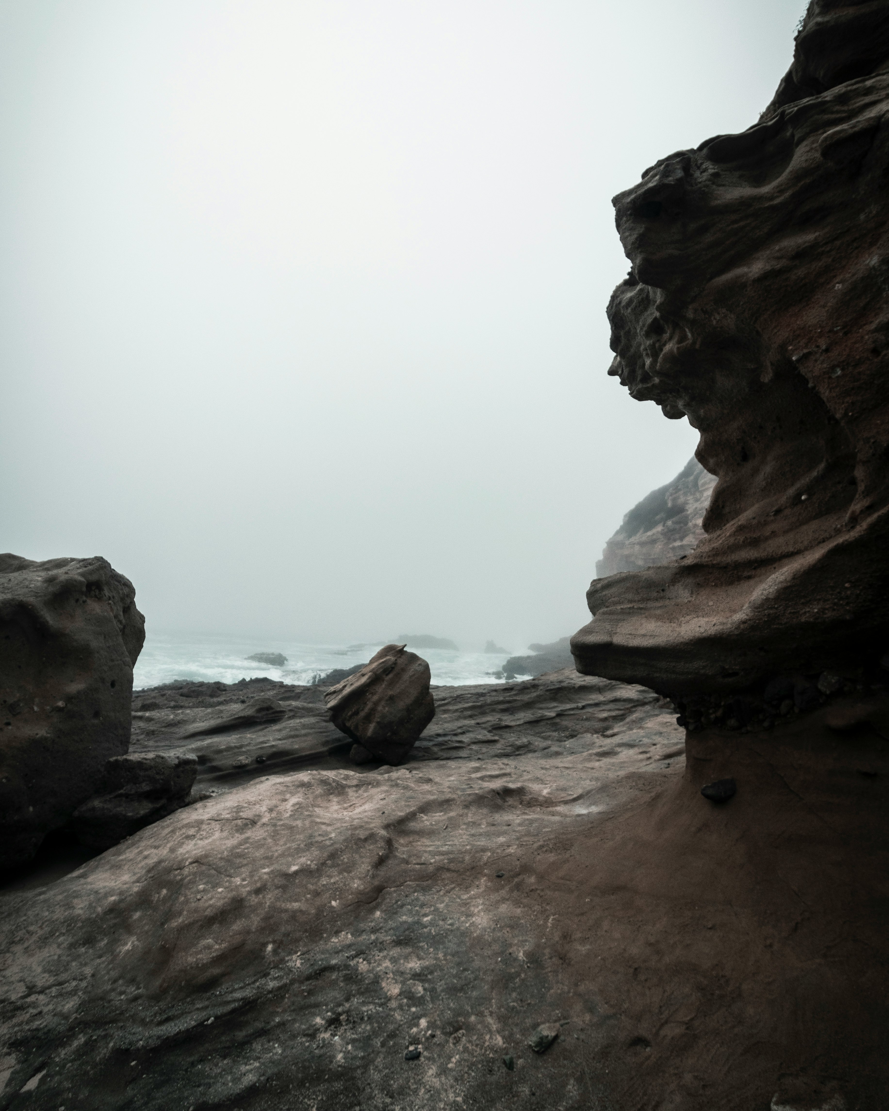 brown rock formation near body of water during daytime